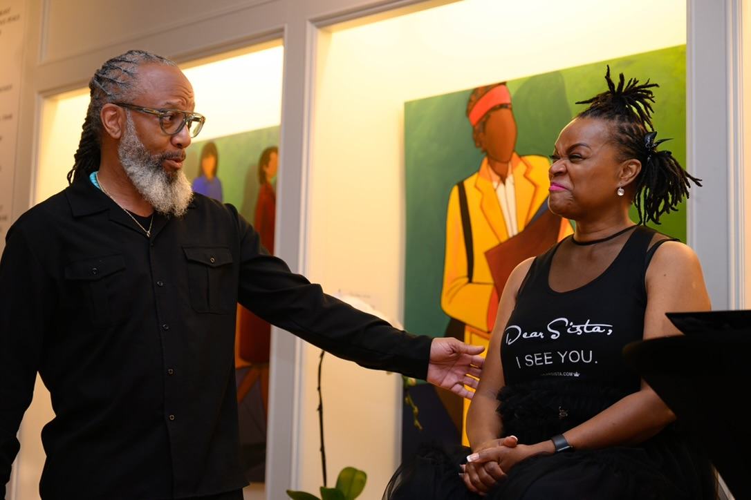 Heru TchaasAmen in conversation with a community member at WOW Gallery